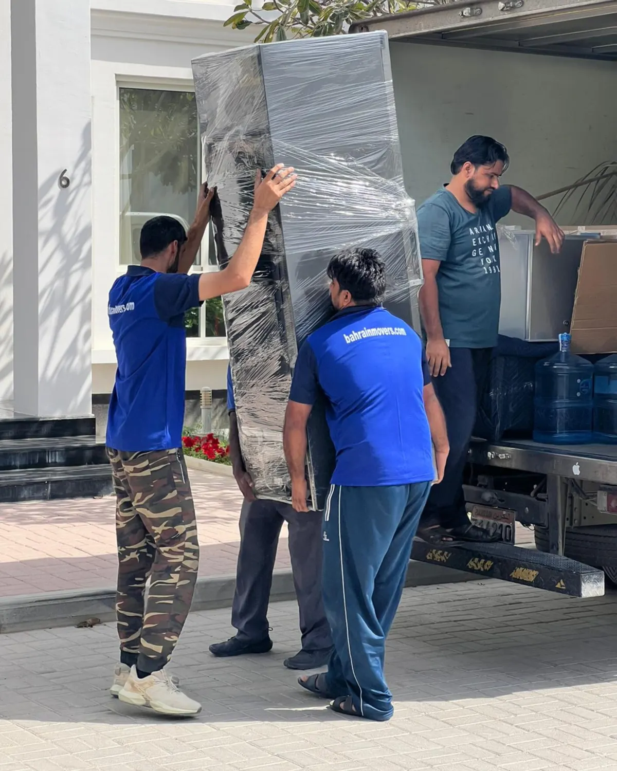 Crew carrying wrapped furniture to the truck