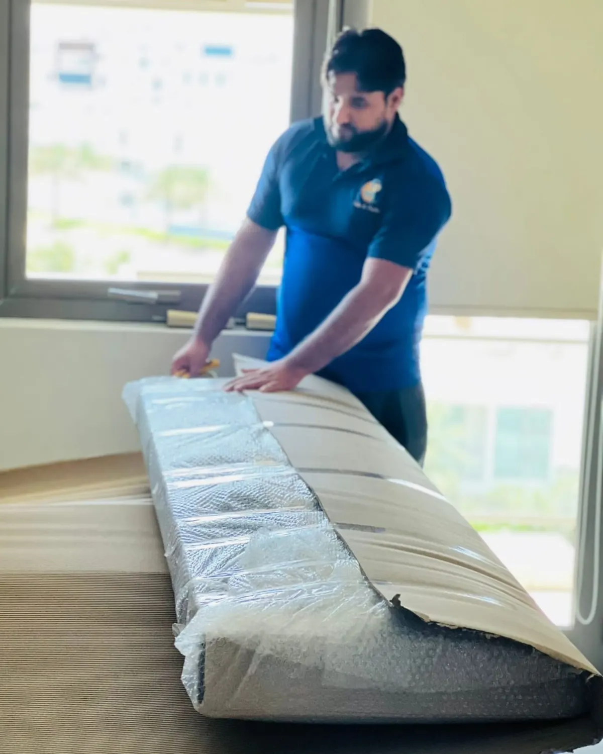 Crew member wrapping a sofa in protective film