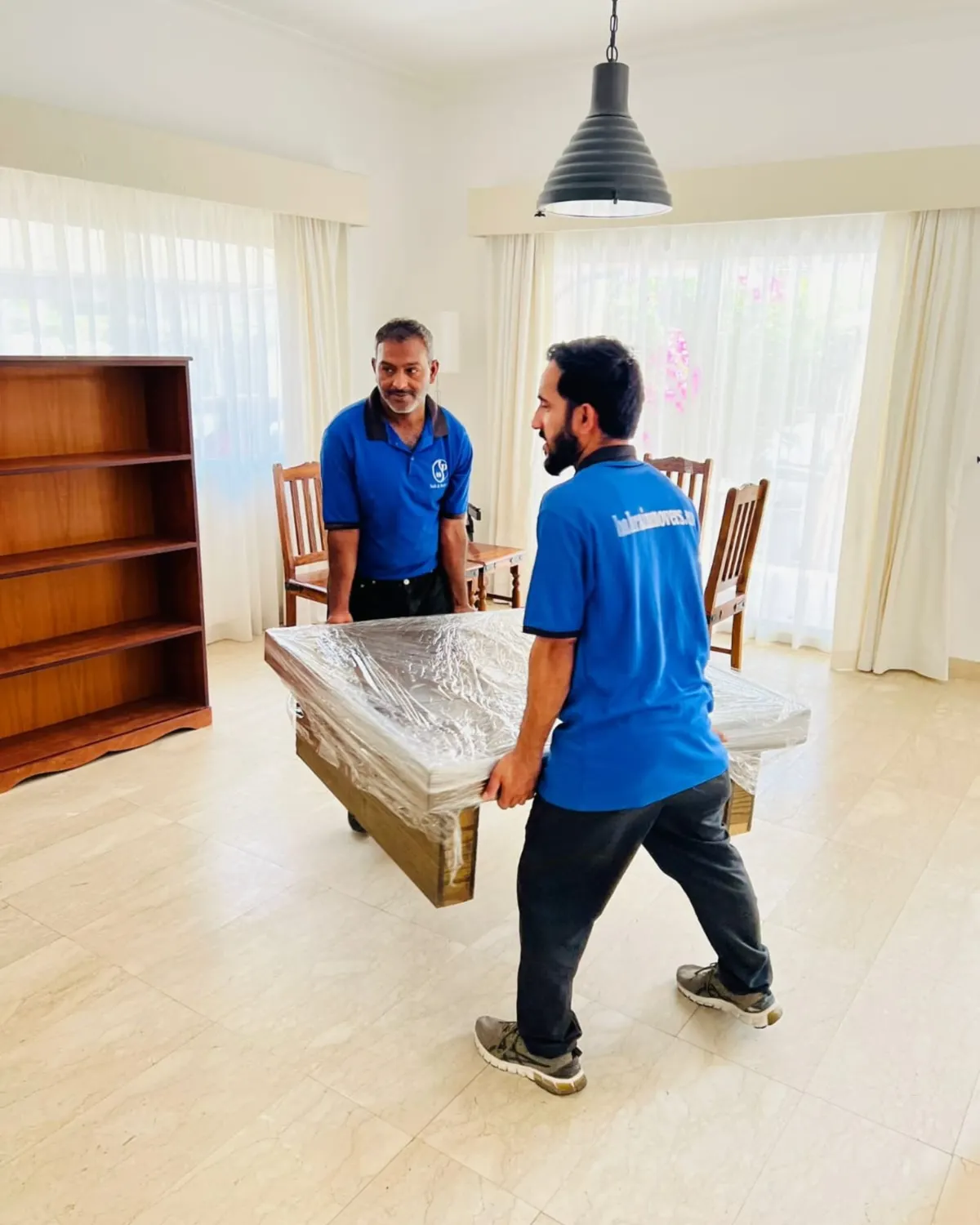 Crew member wrapping a dining table before the move
